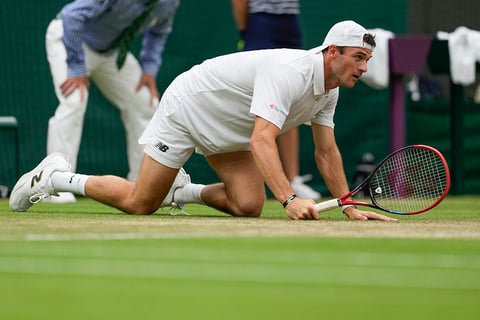 Tommy Paul falls during his match against Carlos Alcaraz